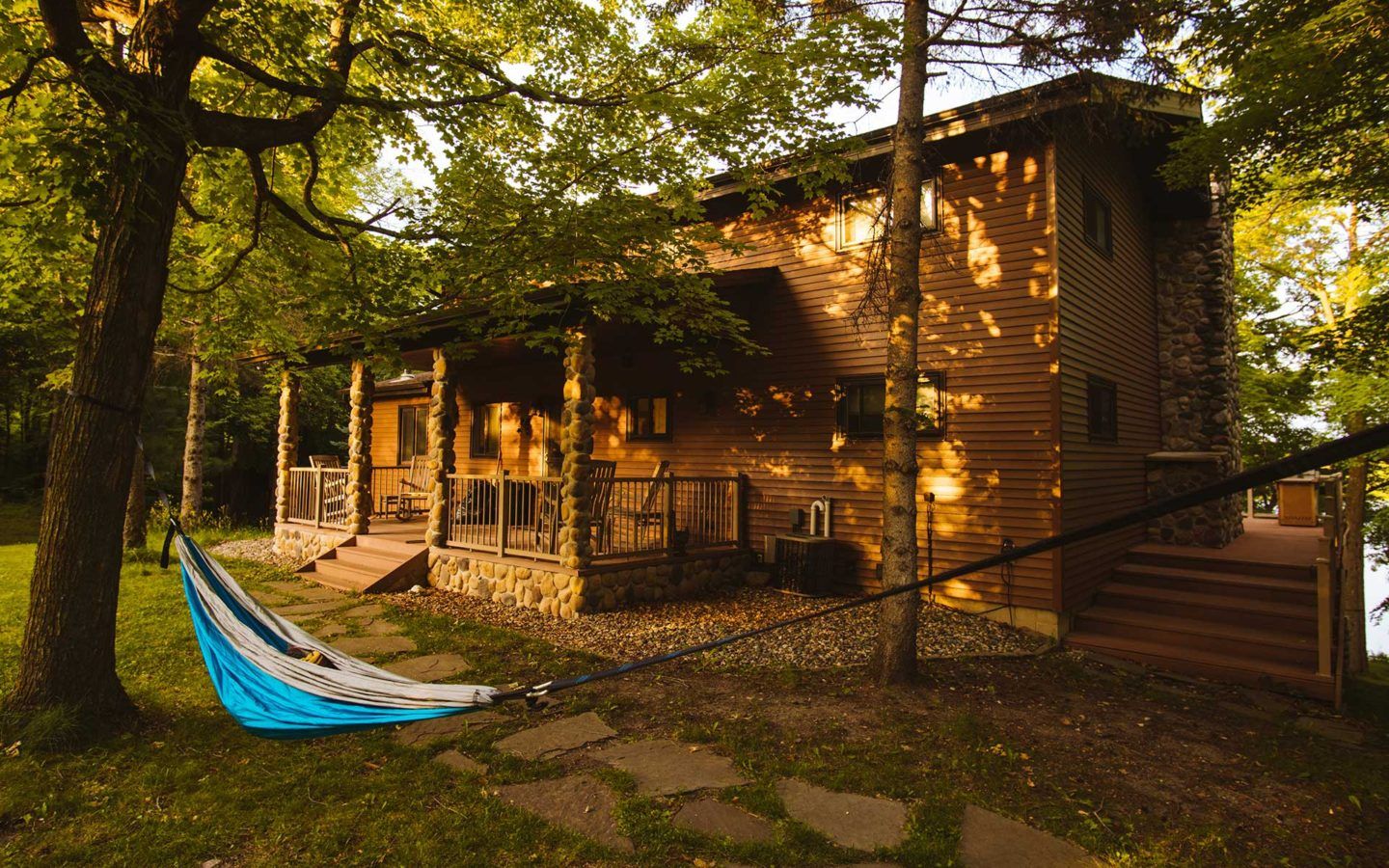 wood sided home with a blue hammock out front