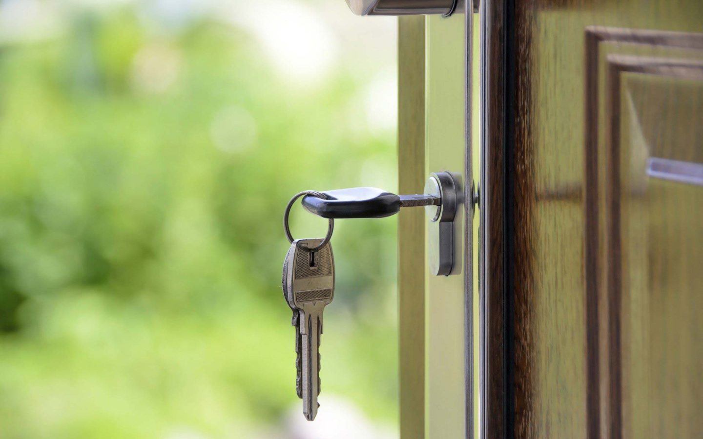 set of keys unlocking a font door of a home